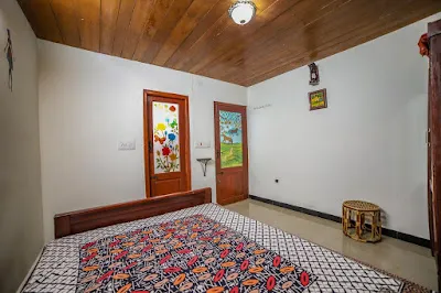 Stone Villa Room 2 with painted glass doors, a timber ceiling and a cane stool